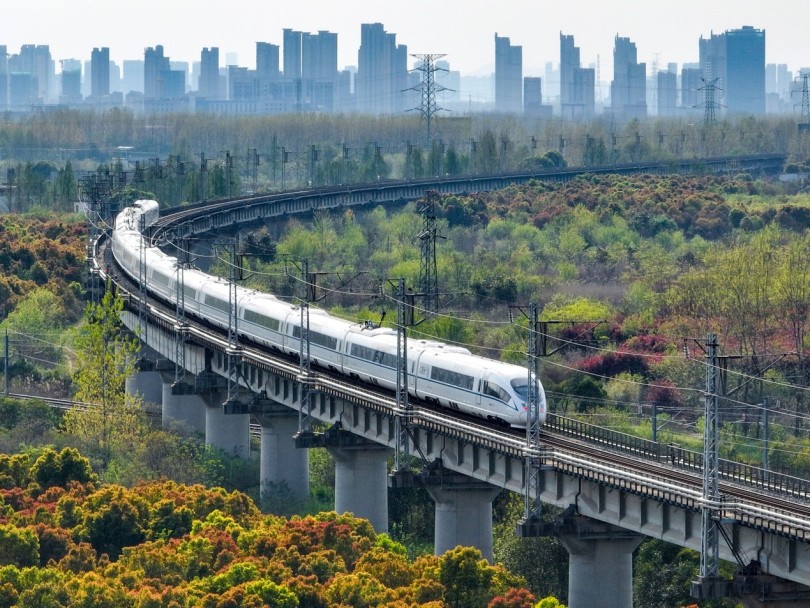 รถไฟจีนวิ่งผ่านทุ่งดอกไม้ในฤดูใบไม้ผลิ